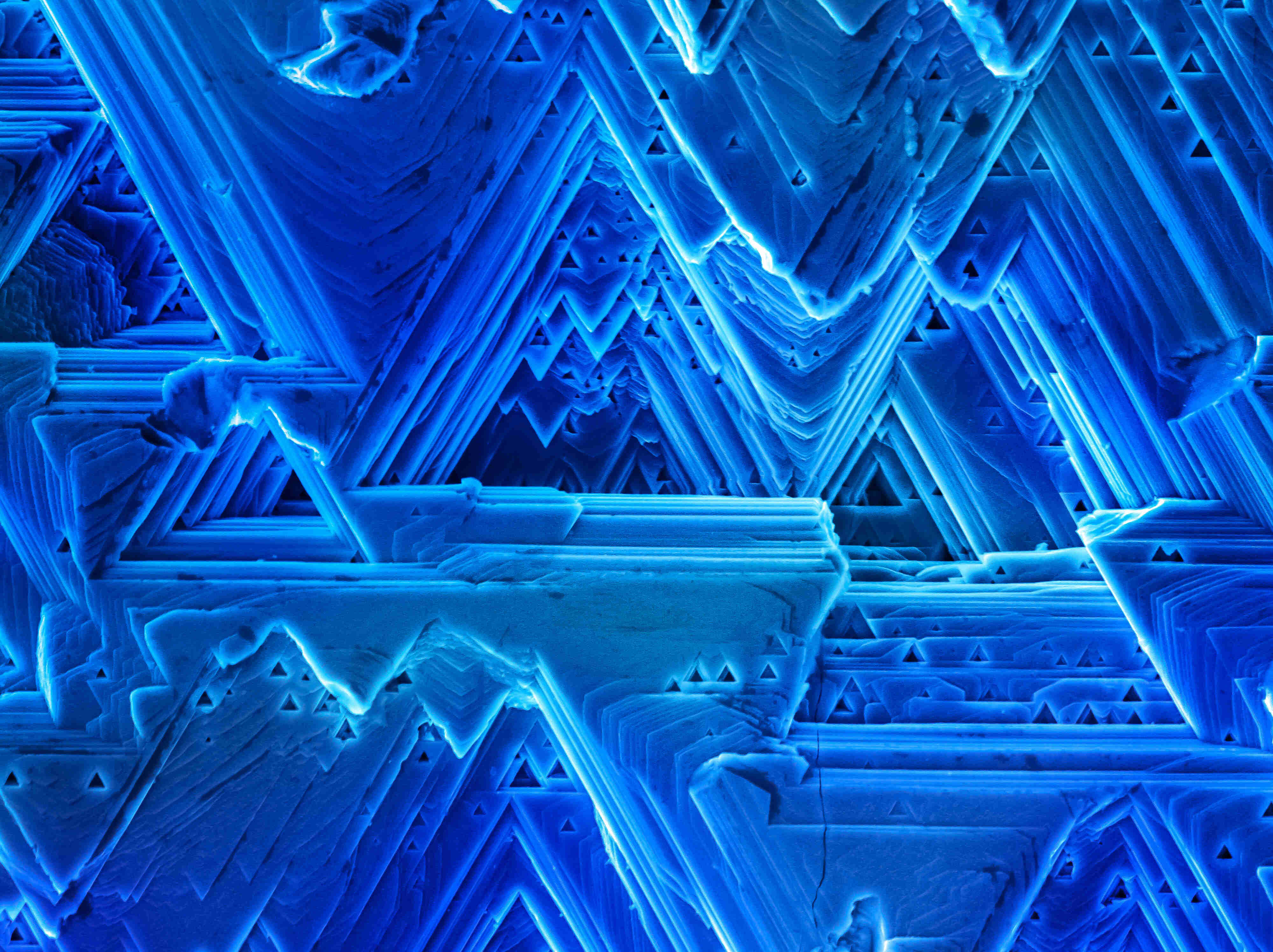 In this micrograph we observe different crystalline microstructures formed during the synthesis of a Copper semiconductor material. The way in which the crystalline layers are stacked to form this material reminds us of the way glaciers are created.